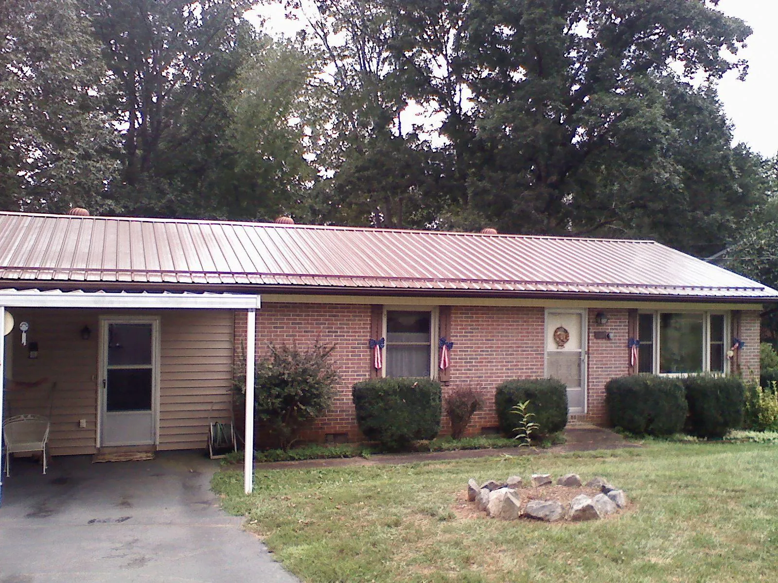 Bronze metal roof and carport on a brick ranch home — Roof Repair work by our crew in Peapack